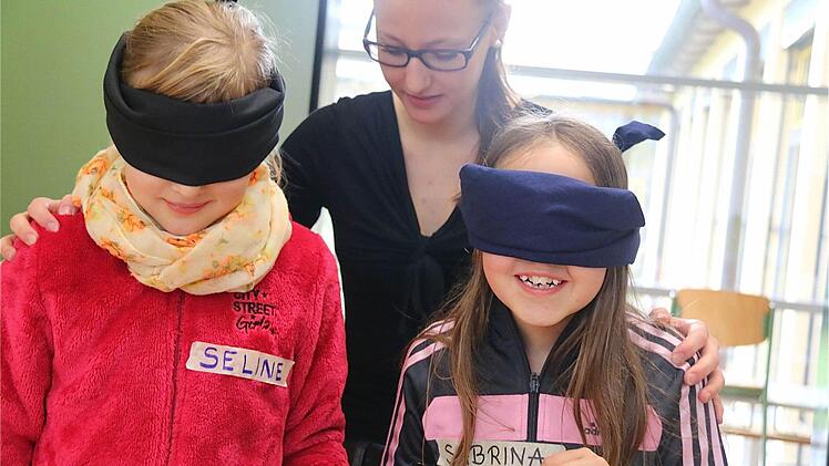 Sorgsam wacht Sarah Rögner aus der Klasse 12Q darüber, dass Selina nicht umkippt, wenn diese blind und mit bloßen Füßen über den vorbereiteten Parcours "Fußfühlstraße" läuft.