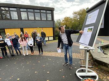 Bad Brückenaus Realschul-Direktor Michael Kreil erklärt den  Fünftklässlern mit einer analogen Präsentation  die Baumpflanzaktion.