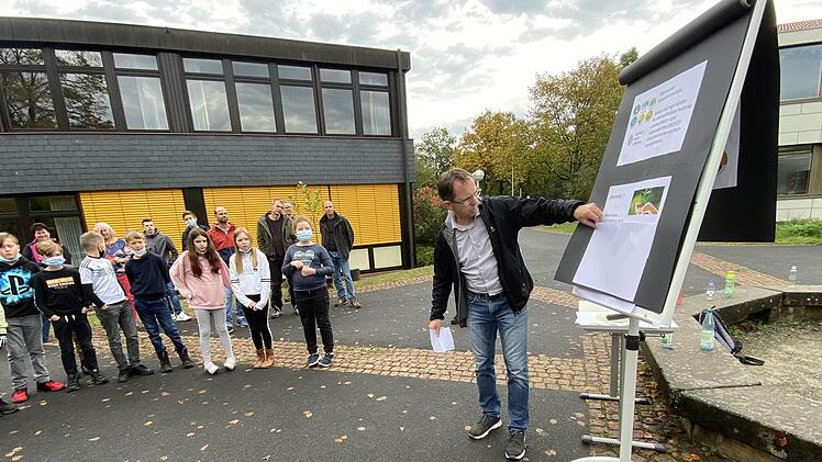Bad Brückenaus Realschul-Direktor Michael Kreil erklärt den  Fünftklässlern mit einer analogen Präsentation  die Baumpflanzaktion.