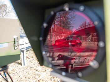 Ein Auto spiegelt sich an einem Kontrollpunkt für den Verkehrsaktionstag "Speedmarathon" im Blitz, der zu einem Gerät zur Geschwindigkeitsmessung gehört.