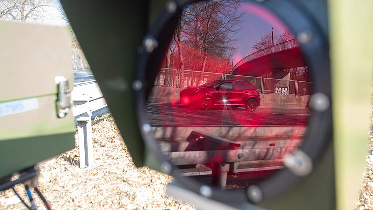 Ein Auto spiegelt sich an einem Kontrollpunkt für den Verkehrsaktionstag "Speedmarathon" im Blitz, der zu einem Gerät zur Geschwindigkeitsmessung gehört.