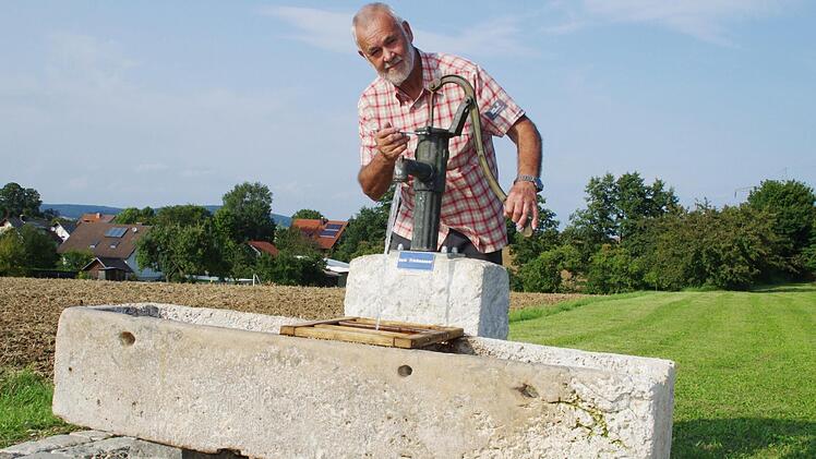 Otto Fischer legt letzte Hand am Wolfsdorfer Brunnen auf dem Sportplatz an, der vor wenigen Tagen aufgestellt wurde. Foto: Thomas Hümmer