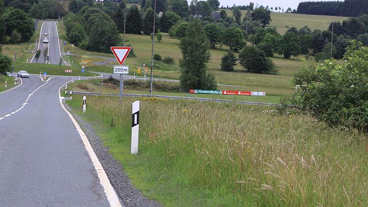 Hier wird in Nordhalben bald ein Radweg gebaut: Fußgänger und Radfahrer, die zum Sportplatz (rechts nach Verkehrsschild) möchten, müssen dann nicht mehr auf der Hauptstraße unterwegs sein. Der Radweg soll im Bereich des Verkehrskreisels im Hintergrund enden. Foto: Michael Wunder