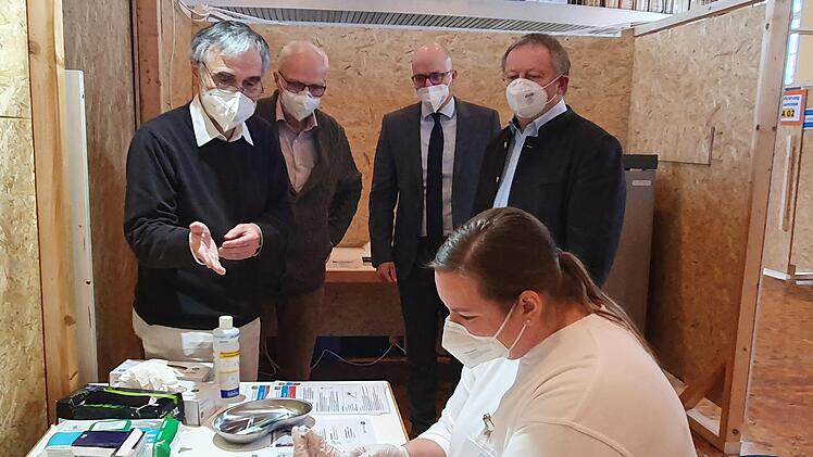 Arzthelferin Tanja Hutzelmann (vorne) zieht den Impfstoff auf Spritzen auf. Dr. Ralph Brath (von links), ärztlicher Leiter des Impfzentrums, erklärt gemeinsam mit seinem Stellvertreter, Dr. Diethard Dittmar, Oberbürgermeister Dr. Dirk Vogel und Landrat Thomas Bold, wie sensibel der Covid-19-Impfstoff der Firma Biontech in der Handhabung ist.