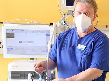 Jürgen Müller, Stationsleiter der Intensivstation und Atmungstherapeut (DGP) zeigt das Beatmungsgerät mit der Applikation für High-Flow Therapieeinschließlich der  "Nasenbrille". Mit dieser erhält der Patient ein Sauerstoffgemisch über die Nase zugeführt.