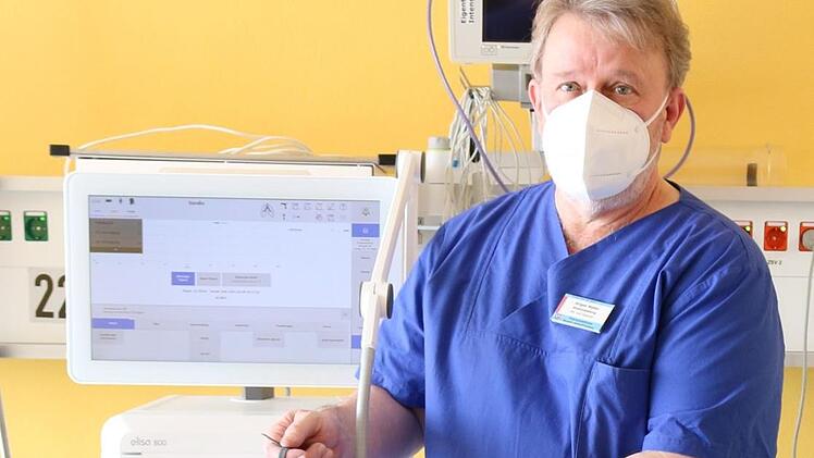 Jürgen Müller, Stationsleiter der Intensivstation und Atmungstherapeut (DGP) zeigt das Beatmungsgerät mit der Applikation für High-Flow Therapieeinschließlich der  "Nasenbrille". Mit dieser erhält der Patient ein Sauerstoffgemisch über die Nase zugeführt.