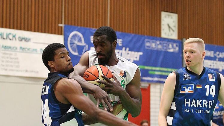 Der Baunacher Rob Ferguson (mit Ball) rennt sich gegen Derrick Marks fest; rechts der ehemalige Bamberger Philipp Neumann. Foto: sportpress