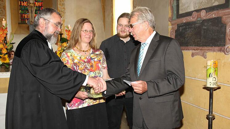 Günther Beland vom Kirchenvorstand überreicht dem neuen Pfarrer symbolisch die Kirchenschlüssel (von links): Pfarrer Wolfgang Leikert, Birigit Leikert, Sohn Berengar und Günther Beland. Foto: Michael Stelzner