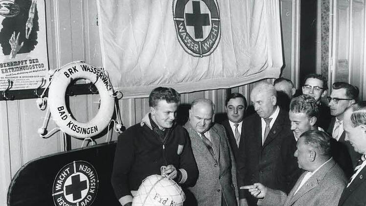 1961: Übergabe eines Rettungsballs. Foto: Wasserwacht/Gerhard Fuhrmann