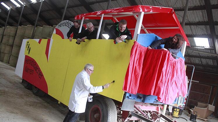 Die  Heroldsbacher Narren schmücken ihren Umzugswagen. "Wir bauen wahrscheinlich am Aschermittwoch oder am darauffolgenden Samstag wieder ab. Schließlich wird der Wagen wieder bei der Arbeit auf dem Hof benötigt", verrät Anita Hofmann, Präsidentin des Fosanochtsvereins. Foto: Maximilian Ott