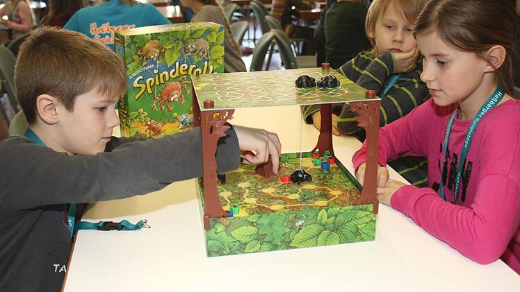 Ganz konzentriert sind (von links) Luca, Liam und Lara, die sich das Spiel "Spinderella" ausgesucht haben.  Foto: Ralf Naumann