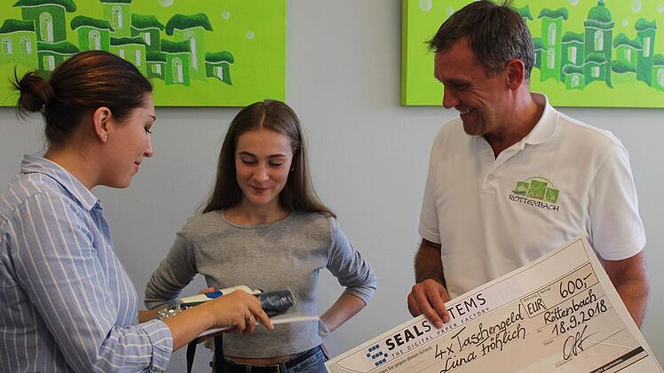 Luna Fr&ouml;hlich bekam zur Freude von Ludwig Wahl nicht nur einen Taschengeldscheck von Carina Ott (l.), sondern auch noch ein paar n&uuml;tzliche Reiseutensilien wie einen kleinen Regenschirm.    Foto: Yannick Hupfer