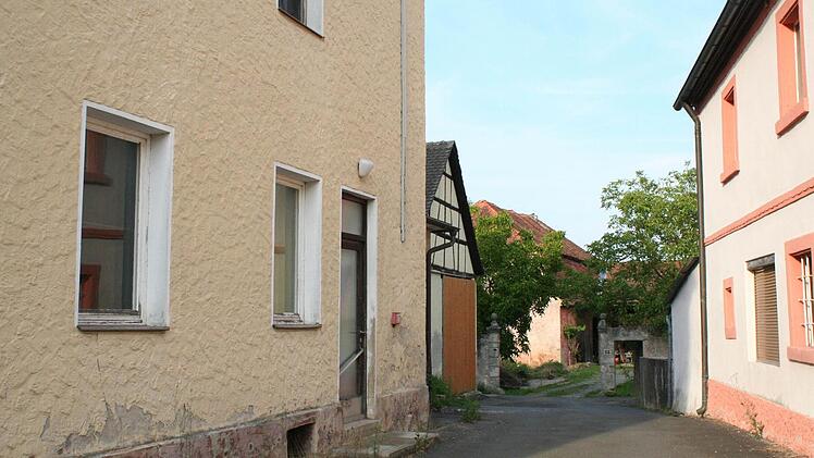 Die Zufahrt zum Schlossbauernhof (im Hintergrund) soll schöner angelegt werden. Links im Bild die alte Schule, deren Abriss beschlossen wurde.