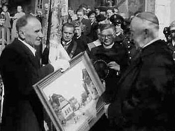 Birkachs Bürgermeister Hans Hümmer (links) überreicht Bischof Dietz anlässlich dessen goldenen Priesterjubiläums am 28. Oktober 1955 ein Gemälde, das das Elternhaus des Bischofs zeigt.Archiv: Edgar Hagel