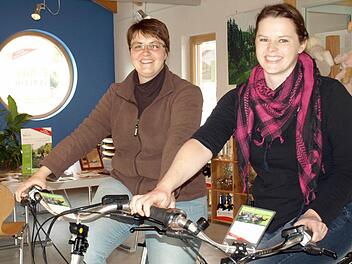 Die neue Leiterin des Tourismusbüros Oberes Rodachtal Katrin Franz (r.) probiert zusammen mit ihrer Kollegin Yvonne Simon die neuen E-Bikes aus.