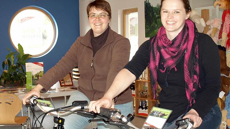 Die neue Leiterin des Tourismusbüros Oberes Rodachtal Katrin Franz (r.) probiert zusammen mit ihrer Kollegin Yvonne Simon die neuen E-Bikes aus.