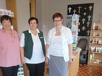 Mitarbeiterin Susanne Lochner, Margitta Seuffert und Geschäftsführerin Angelika Somaruga freuen sich, dass sich der neue Klosterladen auf dem Kreuzbert freundlich und hell präsentiert. Kreuze, Kerzen, Karten und Kosmetik können Gäste dort zum Andenken kaufen. Foto: Marion Eckert