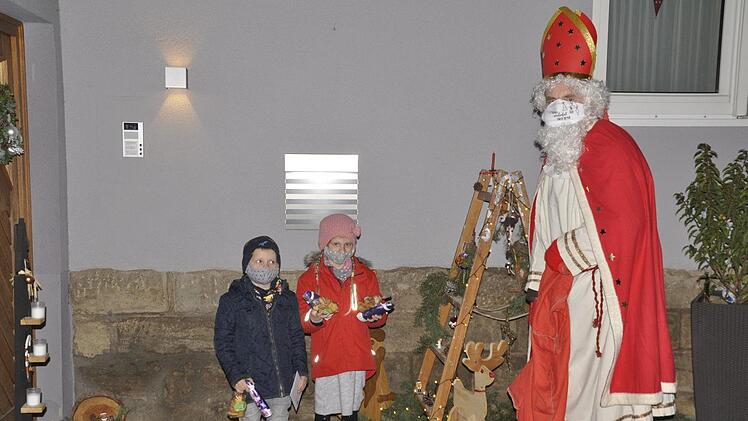 Mit Mund-Nasen-Maske und im entsprechenden Abstand nahmen Henrik und Maxima vom "Feuerwehr-Nikolaus" ihr Geschenk entgegen. Foto: Peter Klopf