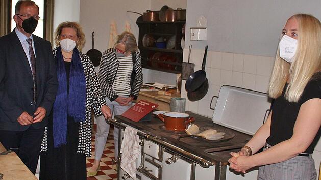 Als w&auml;re die K&ouml;chin eben gegangen: (von links) Bezirkstagspr&auml;sident Erwin Dotzel, seine Stellvertreterin Eva Maria Linsenbreder und Museumsleiterin Josefine Gl&ouml;ckner. Foto: Werner Vogel