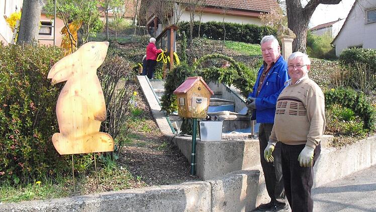 Zum Schluss wird der Osterbrunnen geschmückt. Foto: Helmut Klösel