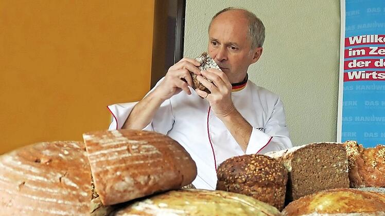 Prüfer Manfred Stiefel vom Zentralverband des Deutschen Bäckerhandwerks testet Brote und Stollen der Mitglieder*innen der Bäckerinnungen Kronach, Coburg und Lichtenfels.
