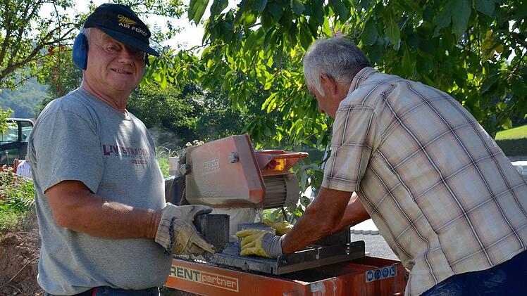 Millimeterarbeit: An der Säge im Schatten sind diesmal Siegfried Schmitt (links) und Michael Kröckel tätig. Sie schneiden Steine zu. Foto: Kathrin Kupka-Hahn