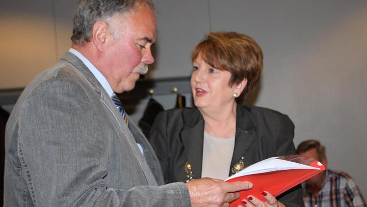 Zum Einarbeiten: Bürgermeisterin Brigitte Meyerdierks überreicht dem neuen Stadtrat Georg Zeitz die Satzung der Stadt. Foto: Ulrike Müller