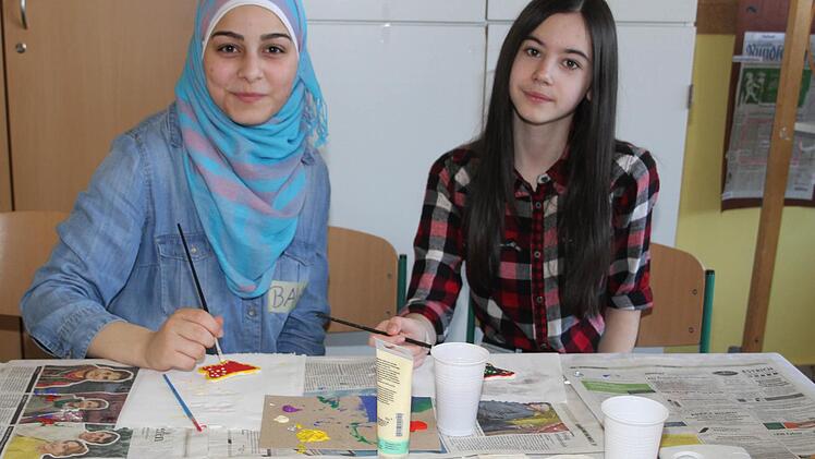 Beim Aktionstag der Schülermitverantwortung hatten sich alle Klassen der Max-Hundt-Mittelschule s etwas einfallen lasssen. Baia Eizeddin (16) aus Syrien und Nada Lociak (12) aus der Ukraine finden es witzig, Schmetterlinge zu bemalen, auch wenn Baia Ostern eigentlich gar nicht kennt. Foto: Sonja Adam
