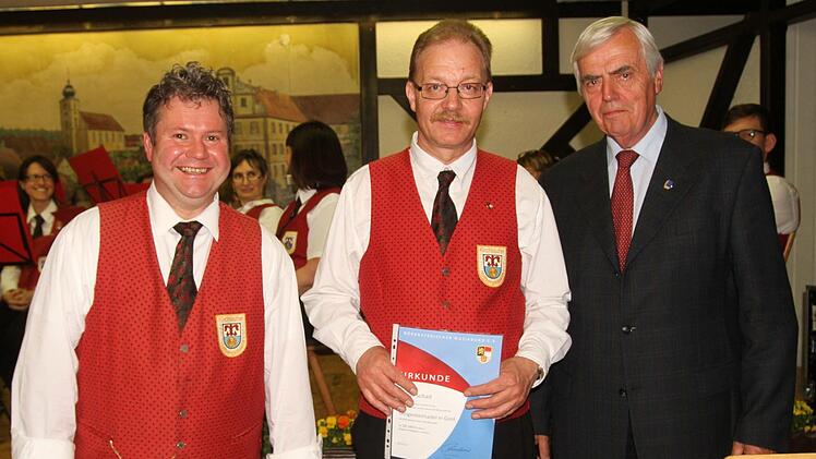 Mit der "Dirigentennadel in Gold" wurde Klaus Schad für seine 30-jährige Tätigkeit ausgezeichnet. Vorsitzender Roland Gehring (links) und NBMB-Ehrenvorsitzender Gerhard Leisentritt (rechts) sprachen die Laudatio.  Foto: Günther Geiling
