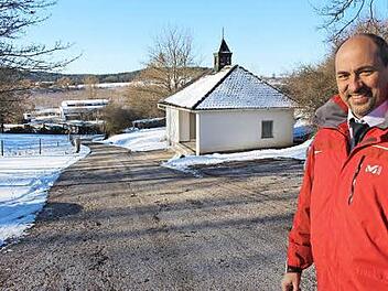 Außerhalb der Einfriedung liegt tiefer am Berg die Leichenhalle. Wenn sich hier Trauergäste versammeln stehen sie zwischen den Autos auf dem der Halle gegenüber liegenden Parkplatz. Um mehr Platz zu gewinnen, sollen einige Parkplätze (links im Bild) vier Meter nach hinten versetzt werden, erklärte Bürgermeister Krapp. Foto: Evi Seeger