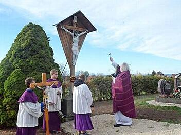 Pater Waldemar Brysch segnet das Friedhofskreuz auf dem Friedhof in Glosberg.  Foto: K.- H. Hofmann