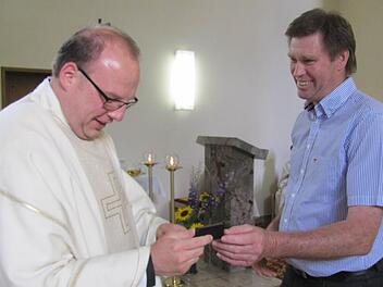 Vorsitzender Günter Becker vom Bürgerverein Creidlitz schenkte Kaplan Norbert Förster zum Abschied eine goldene Krawattennadel mit dem historischen Wappen der früher selbstständigen Gemeinde Creidlitz. Foto: Martin Koch