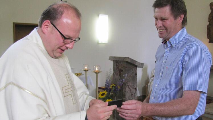 Vorsitzender Günter Becker vom Bürgerverein Creidlitz schenkte Kaplan Norbert Förster zum Abschied eine goldene Krawattennadel mit dem historischen Wappen der früher selbstständigen Gemeinde Creidlitz. Foto: Martin Koch