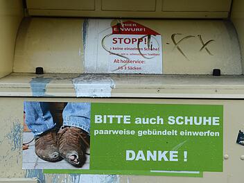 Kuriose Rettung: Eine Frau zeigt, warum man erst alle Taschen kontrollieren sollte, bevor man Kleidungsst&uuml;cke in den Kleidercontainer wirft. Foto: Jens Kalaene/dpa