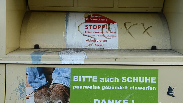 Kuriose Rettung: Eine Frau zeigt, warum man erst alle Taschen kontrollieren sollte, bevor man Kleidungsst&uuml;cke in den Kleidercontainer wirft. Foto: Jens Kalaene/dpa