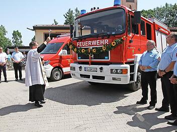 Pfarrer Matthias Steffel weiht die Fahrzeuge der FFW Hallerndorf.