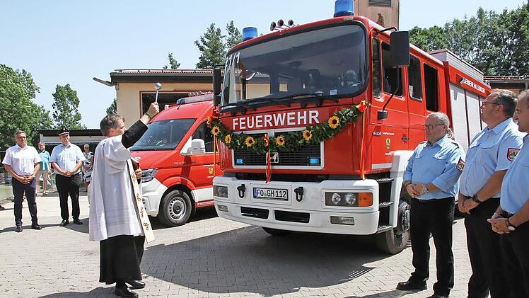 Pfarrer Matthias Steffel weiht die Fahrzeuge der FFW Hallerndorf.