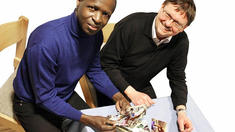 Zuversichtlich: Soungalo Magassa (links) will gemeinsam mit dem Höchstadter Pfarrer Hans-Friedrich Schäfer Hilfe für sein Heimatland Mali organisieren. Die Bilder aus dem Dorf, wo er aufgewachsen ist, zeigen, in welcher Armut die Menschen leben. Durch den aktuellen Konflikt, hat die Hungersnot noch zugenommen. Foto: S.Martin