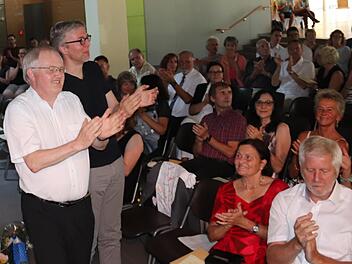 Kurt Spitzer und Jürgen Paul klatschen begeistert dem Orchester Beifall, rechts Schulleiter Bernd Lohneiß. Foto: Johanna Blum