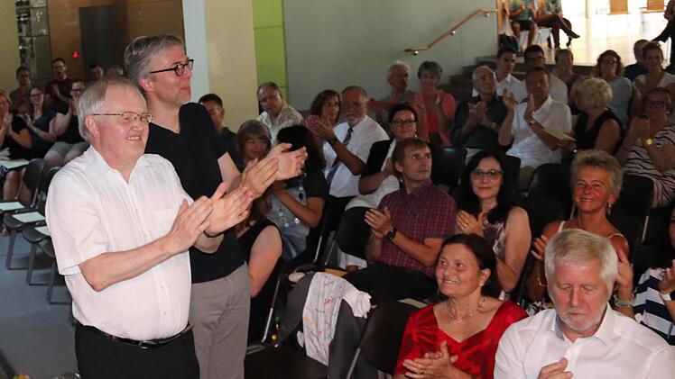 Kurt Spitzer und Jürgen Paul klatschen begeistert dem Orchester Beifall, rechts Schulleiter Bernd Lohneiß. Foto: Johanna Blum