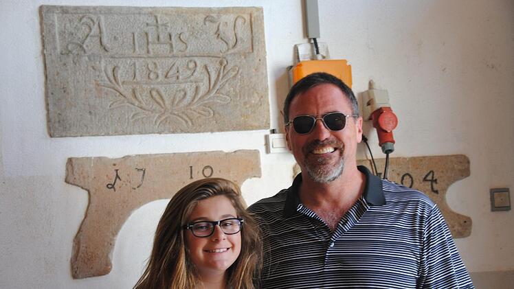 Greg Fondran mit Tochter Jadyn vor dem Sandstein, den ihr UrUrUrGroßvater Adam Vorndran einst angefertigt hat.  Foto: Anton Enders