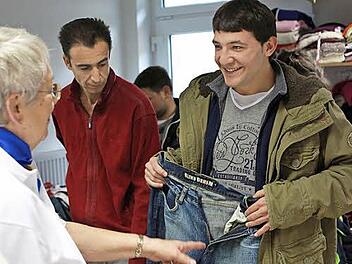 Hildegard Felix übergibt dem jungen Syrer Sami eine neue Jeans.
