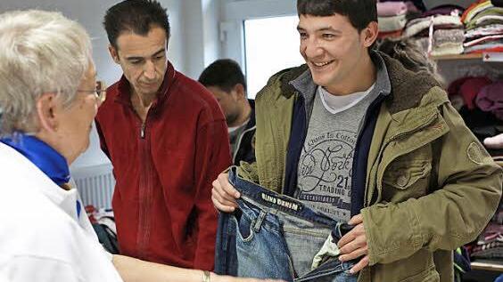 Hildegard Felix übergibt dem jungen Syrer Sami eine neue Jeans.