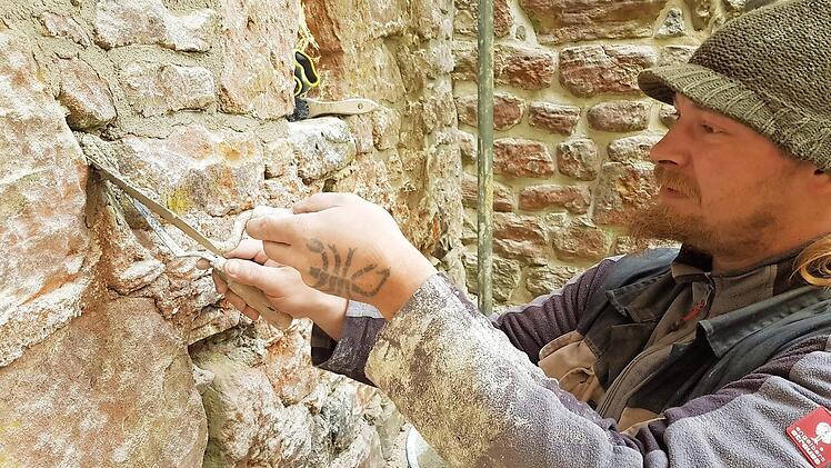 Rafael Sereda füllt die Fugen im Mauerwerk mithilfe zweier Spachteln. Wenn's jetzt kälter wird, zieht der Spezialmörtel nicht mehr an.
