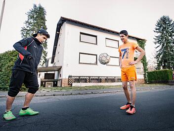 Redep (14 Jahre, links) und Robert Uka (12) kicken auf der Straße vor dem Haus in Mitwitz, in dem ihre Familie untergekommen ist.  Fotos: Steffens