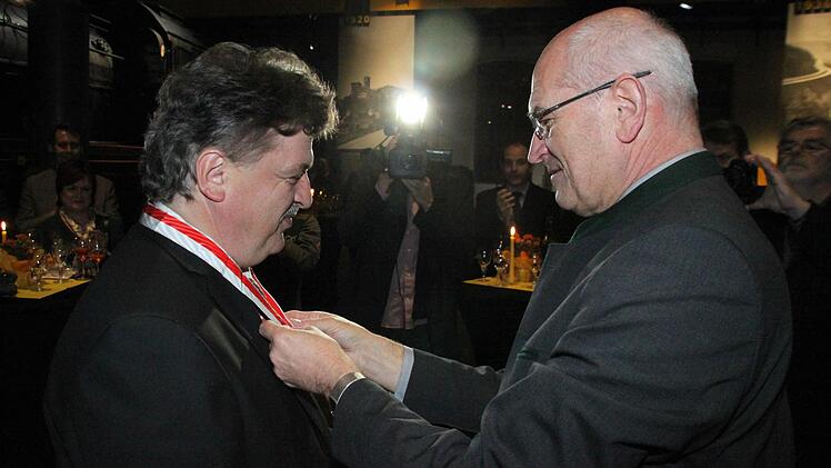Bezirkstagspräsident Günther Denzler übergibt die Ehrenmedaille des Bezirks Oberfranken in Silber.