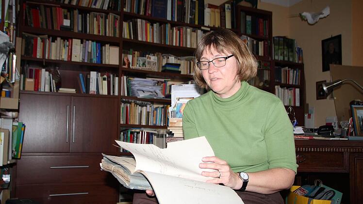 Pfarrerin Barbara Weichert blättert durch die Kirchenakte der Jahre 1850 bis 1903. Foto: Ulrike Müller