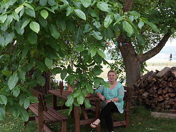 Karin Happ sitzt unter dem ausladenden Walnussbaum.Foto: Arkadius Guzy