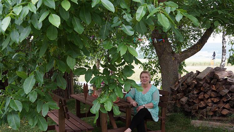 Karin Happ sitzt unter dem ausladenden Walnussbaum.Foto: Arkadius Guzy