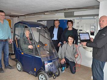 Hier wird das E-Mobil von Josef Behrendt aus dem Speicher der Photovoltaikanlage "aufgetankt" zur nächsten Einkaufsfahrt. Von links: Roland Behrendt, Josef Behrendt, Bürgermeister Rainer Detsch, Sabine und Chris Behrendt sowie Manfred Drechsler, der das Home-Managementsystem installierte und betreuen wird.  Foto: Karl-Heinz Hofmann